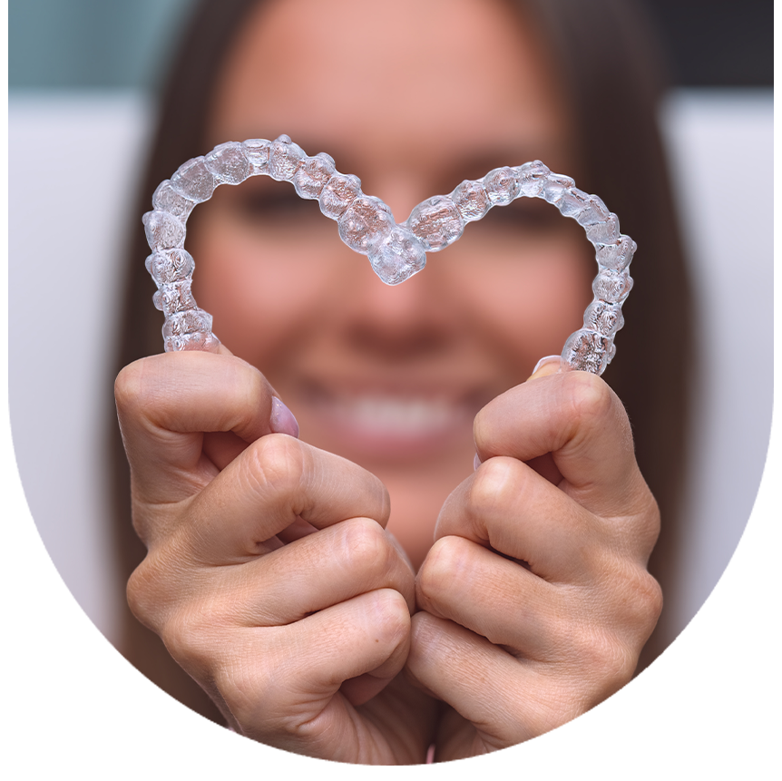 The image features a person holding up a pair of heart-shaped braces with their hands, smiling at the camera.